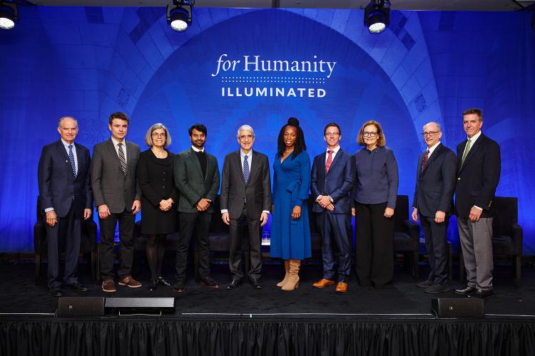 Presenters pose for a group photograph on stage at For Humanity Illuminated in Boston