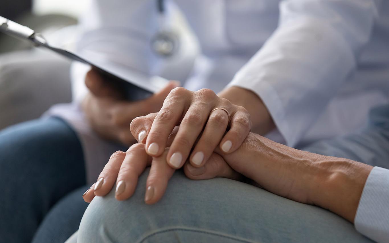 Closeup of a doctor holding a patient's hand