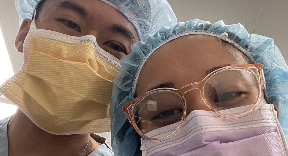 Two doctors take a selfie in protective garb